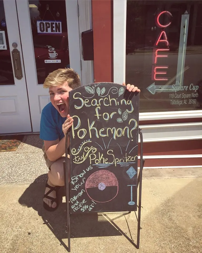 The Square Cup employee posing with a sign.