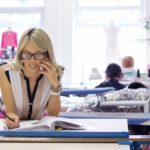 sales woman on phone with customer taking notes down
