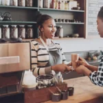 Barista handing a customer a latte.
